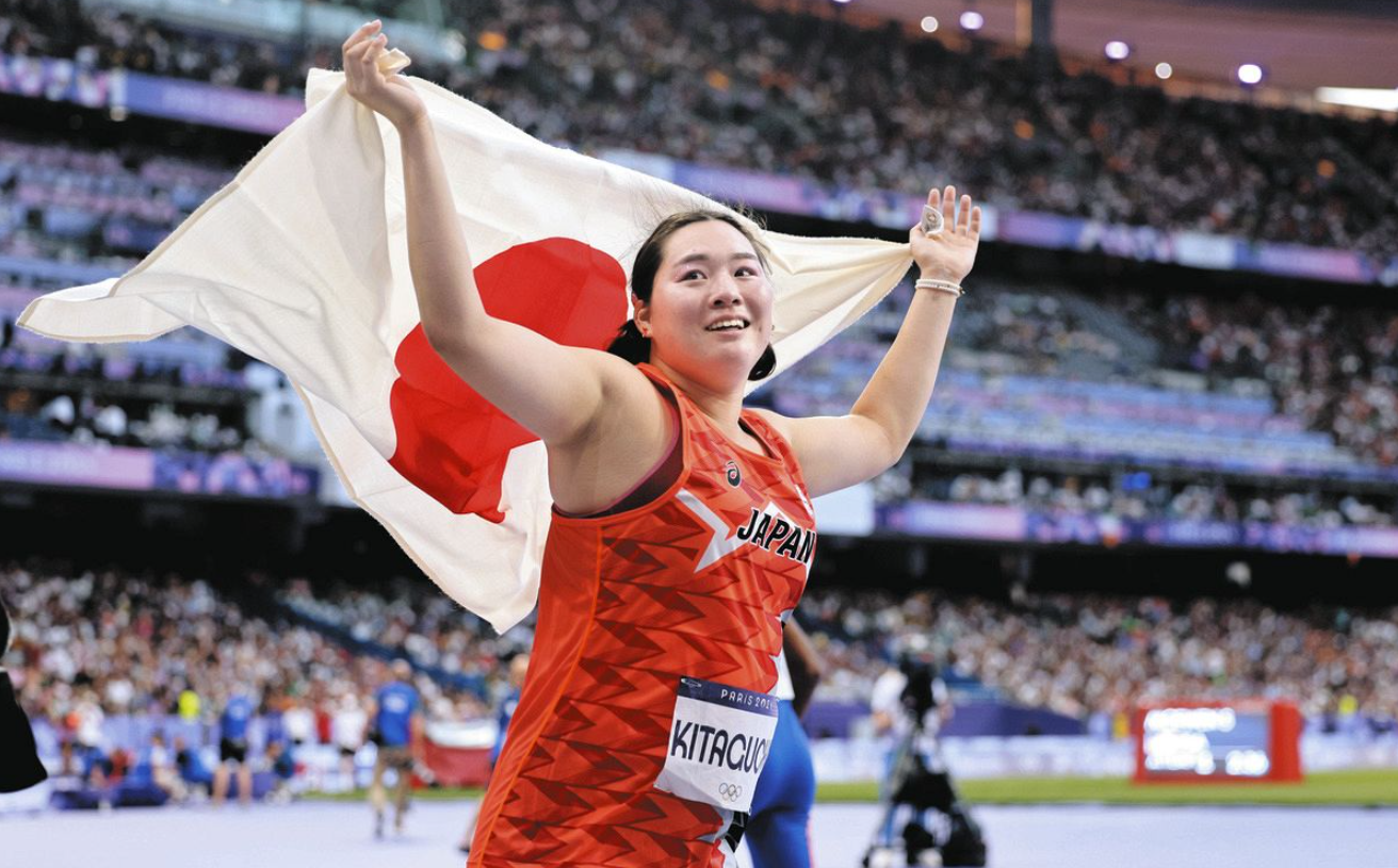 女子やり投げで金メダルを獲得し、日の丸を掲げる北口榛花