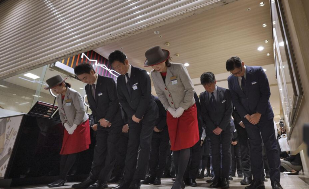 最後の営業を終え、来店客らに頭を下げて閉店する名鉄百貨店の石川仁志社長(左から2人目)と本店の従業員ら=28日夜、名古屋市(KYODONEWS)