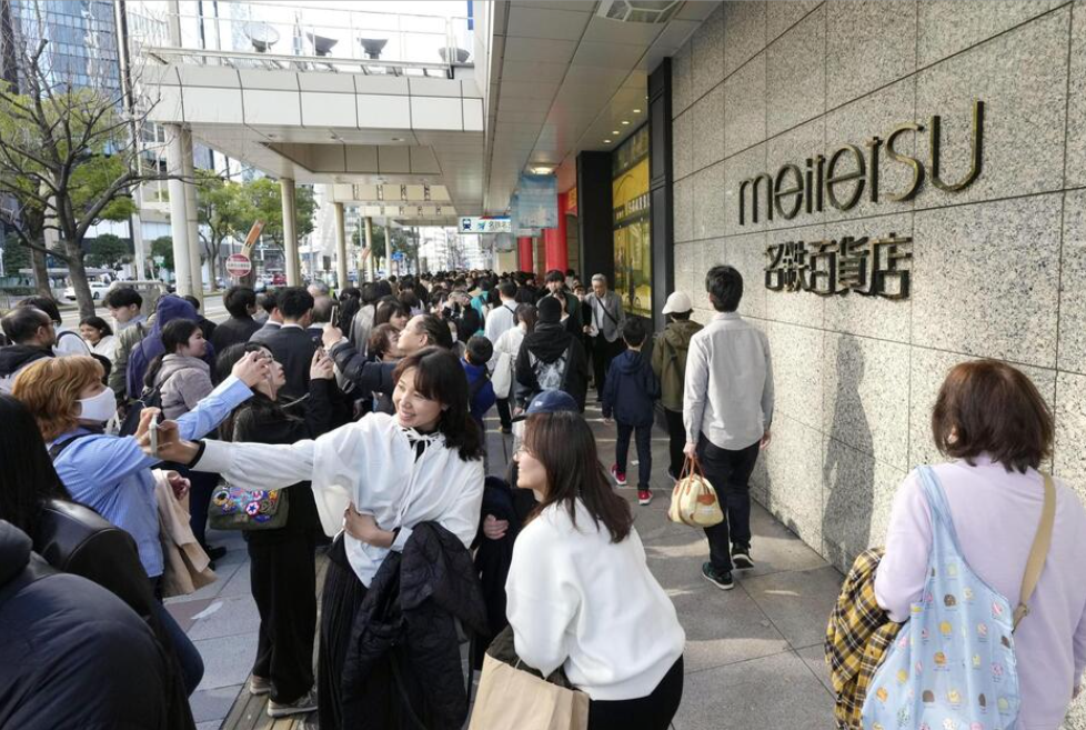 閉店日を迎えた名鉄百貨店本店前で記念撮影する買い物客ら=28日午後、名古屋市(KYODONEWS)